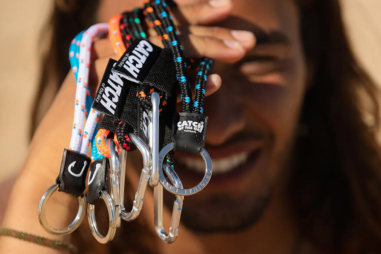 Original Keyrings Ein Mann hält mehrere Keyrings von Original in der Hand